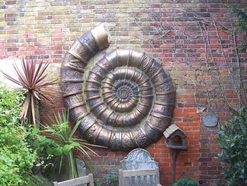 The ammonite in the wall of the garden at the rear of the arts centre was made by the Dorset Pottery Group to celebrate the millennium. It consists of eighty individual segments, the outer ones each depicting a scene from Dorset’s history.
