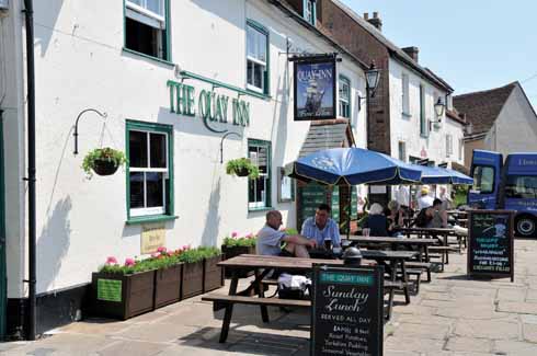 Hanging baskets and flower troughs brighten the summertime Quay