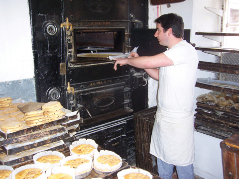 Steven Oxford puts another batch of flapjacks into the venerable oven at the bakery in Alweston