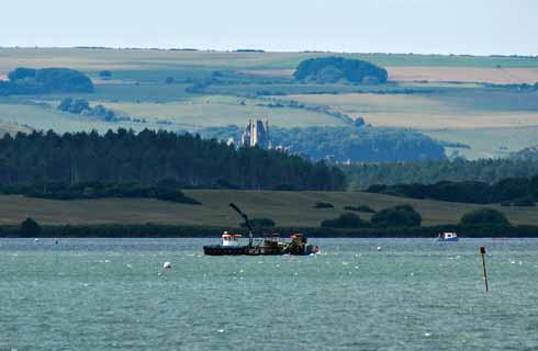 311edOthniel3 The ‘eco-harvester’ above the shellfish beds in Poole Harbour, with Corfe Castle beyond