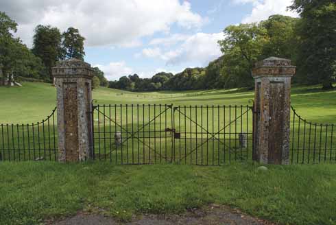 Parkland protected by iron gates just opposite the 17th-century Manor House in Piddletrenthide