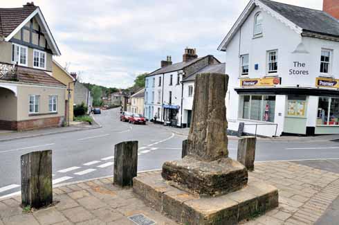 411edMaidenNewton3 The old market cross stands at the junction of Dorchester Road and Church Road. The five-foot-high cross was moved from its original position in 1998 to protect it from likely traffic damage. From a distance, there is little to discern, but closer to, the west face of has much-weathered figures standing on a corbelled projection. It dates probably from the 15th century.