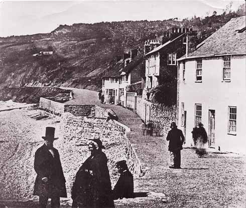 The earliest photograph of The Walk, taken in the 1850s, probably even in the early 1850s. The Assembly Rooms are behind the photographer. The Walk is well gravelled, and the slope behind the beach very bare. The square sticking out from the path is the remains of West Fort, built in 1627 and removed in 1862.