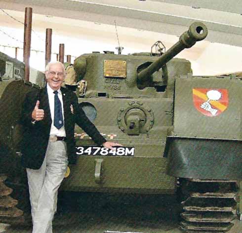 Ray Sansom in front of a Churchill tank at Bovington Tank museum