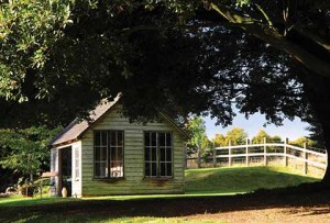 The summer house nestling on the grassy bank